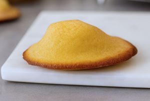 Madeleines légères maison: dorées et bombées posée sur une plaque de marbre blanc