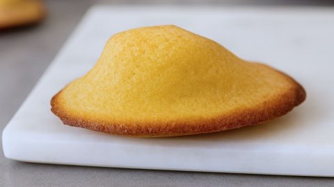 Madeleines légères maison: dorées et bombées posée sur une plaque de marbre blanc